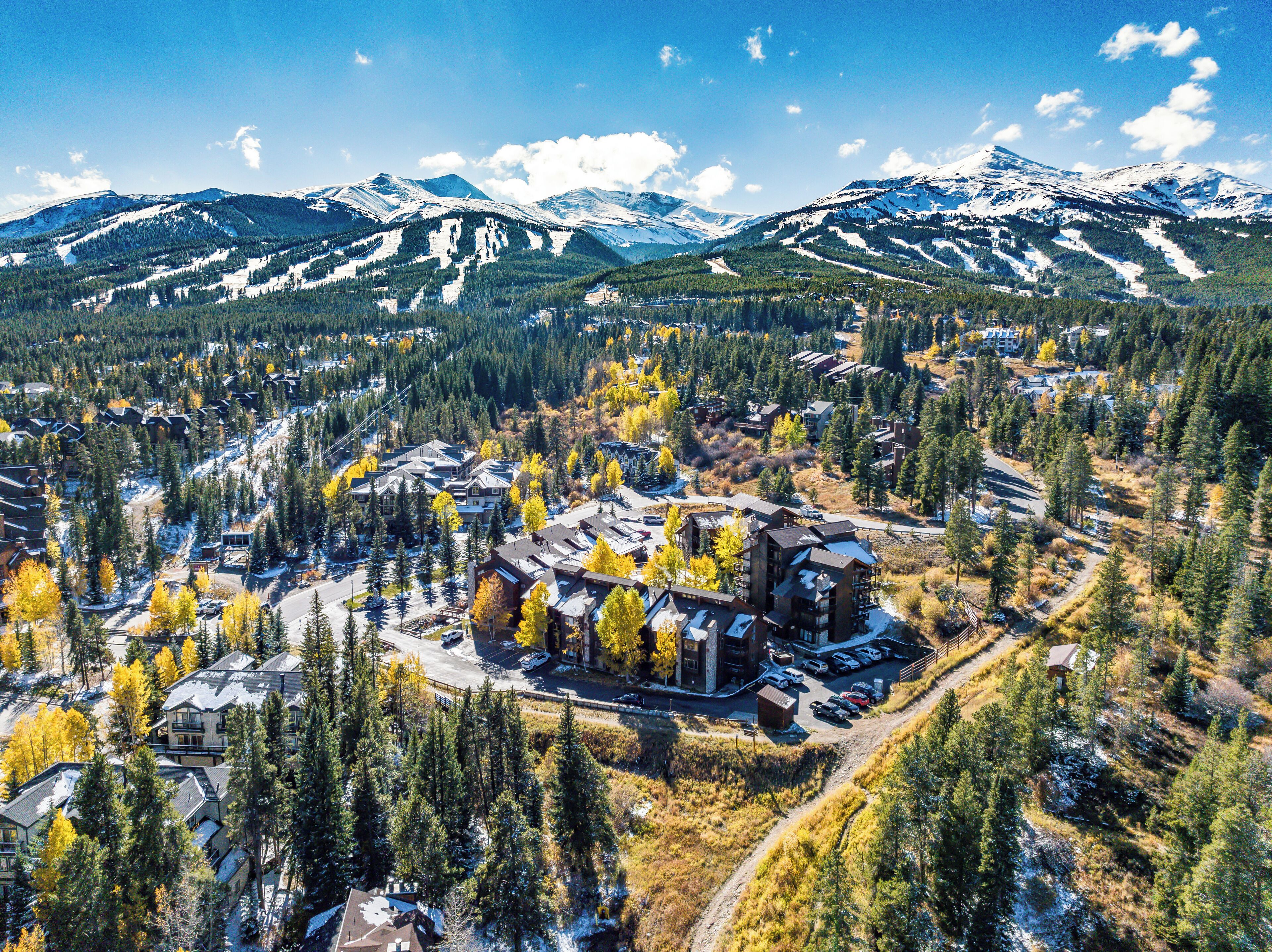 Ein Resort mit mehreren Gebäuden, einem Parkplatz und einer Bergkulisse.