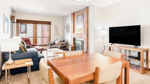 Uma sala moderna com um sofá, uma mesa de jantar e uma televisão.