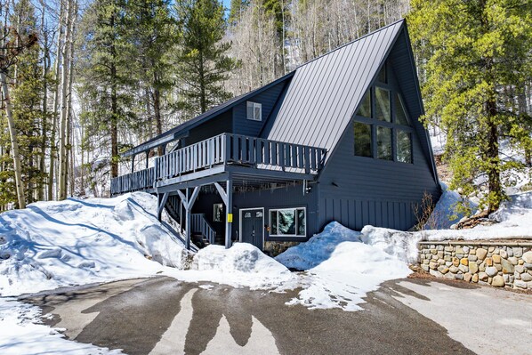 A cabin with a sloped roof, a balcony, and a stone wall. - Adventure Awaits! Cozy Aframe 5 Min to Breck. (Breckenridge)