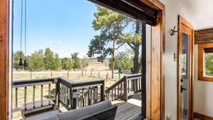 A wooden deck with a bench and a door leading outside. - Meet me in the Rockies! Cute cabin 30 min to Breck (Fairplay)