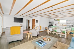 A modern living room with a sofa, a coffee table, and a dining area with chairs and a table. - Whole House FRONT ROW! No obstructions, just remodeled! (Freeport)