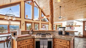 A kitchen with a large island, wooden cabinets, and a stove.
