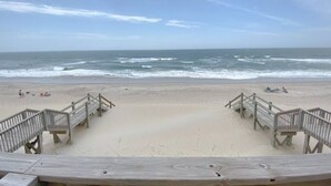 A beach with wooden walkways leading to the shore, a sandy beach, and the ocean in the background. - Twin Landings | Two Homes, One Epic Family Escape! (Surf City)