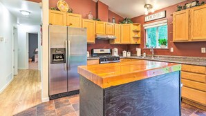 Una cocina moderna con armarios de madera, electrodomésticos de acero inoxidable y una isla grande.