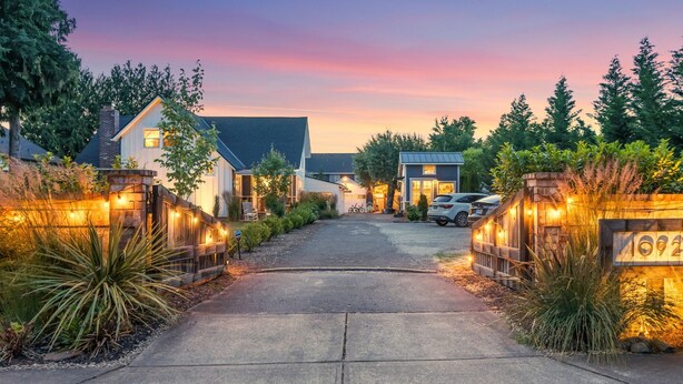 A driveway leading to a residential area with houses, a car, and a sign with the number 092. - 1910 Farmhouse: Chef’s Kitchen + Fire Pit + Studio - Near Wedding & Wine Country (Wilsonville)