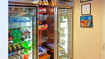 A vending machine stocked with snacks and beverages, including Doritos and Pepsi, in a hotel setting.