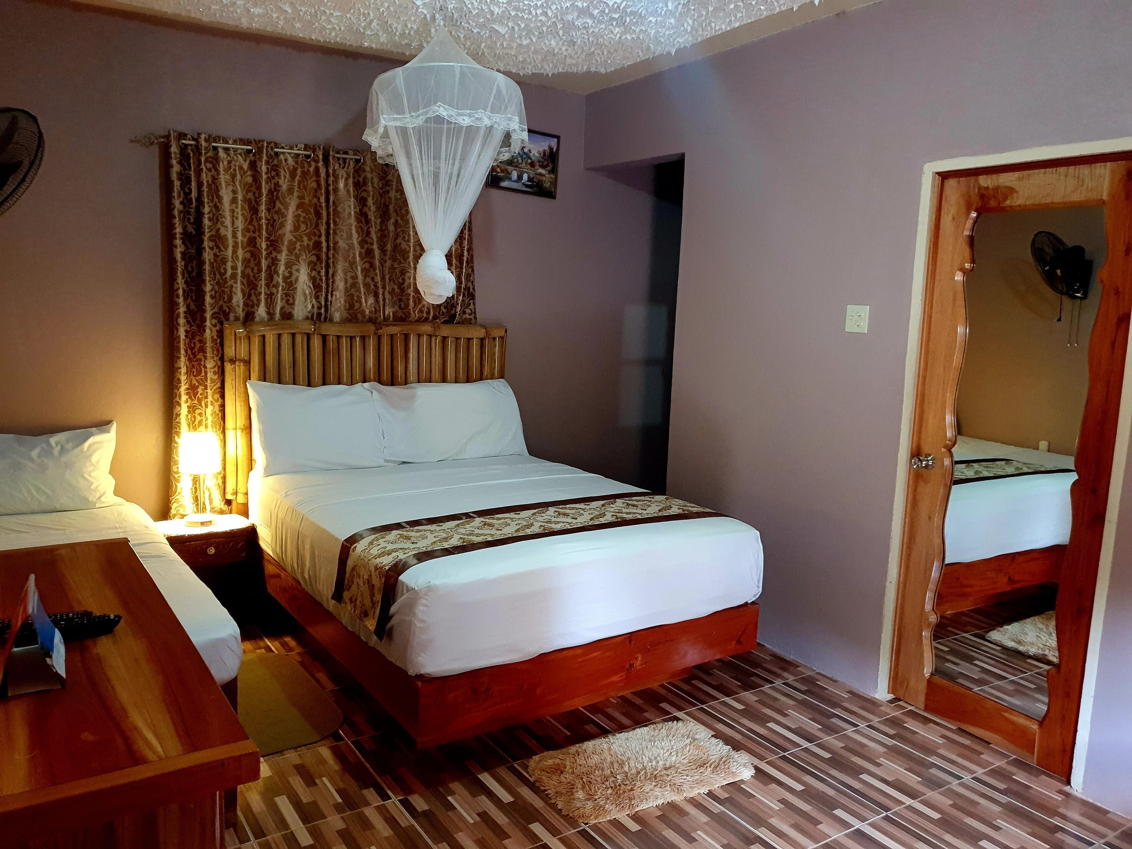 A neatly arranged bedroom with a bed, bedside table, and a wooden nightstand.