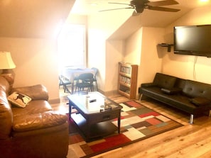 Relax in this inviting living room with a high ceiling, leather sofa, and comfortable seating area.