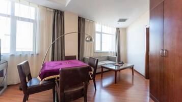 Quarto de hotel com cama, escrivaninha, cadeira, sofá, abajur e guarda-roupa.