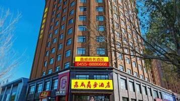 Un edificio de varios pisos con un llamativo letrero amarillo que indica un hotel para negocios.