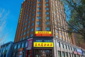 A multi-story building with a prominent yellow sign indicating a business hotel. - Xinwei Business Hotel (Suihua)