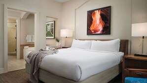 A hotel room with a large bed, a nightstand, a desk, a chair, a bathroom with a towel rack, and a painting on the wall. - Marriott's Canyon Villas: Direct from Owner, Luxury 2 bedroom Thanksgiving  Week (Phoenix)