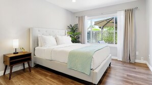 A bedroom with a bed, a nightstand, a ceiling fan, and a window with curtains. - Bright Cozy 3b/2b with nice backyard & BBQ (San Diego)