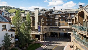 A multi-story hotel with a central courtyard, stone facade, and balconies.