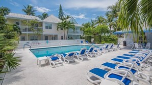 A pool area with lounge chairs and a building with a white fence in the background. - MAI TAI TERRACE - KEY WEST (Key West)