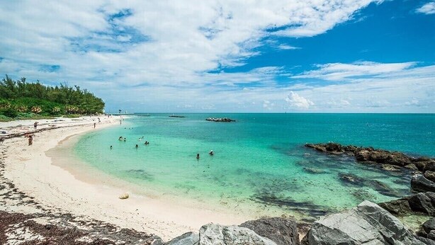 A beach with clear turquoise water, a sandy shore, and rocky outcrops. - MAI TAI TERRACE - KEY WEST (Key West)