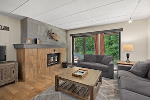 Relax by the fireplace in this inviting living room with a sofa, coffee table, and TV.