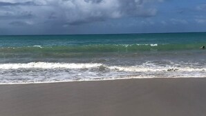 A beach with a wide sandy shore and a view of the ocean.