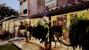 A building with a patio area, outdoor seating, and potted plants.