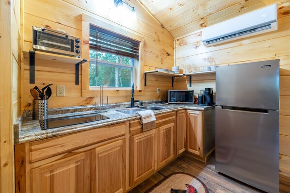 A modern kitchen with wooden cabinets, a stainless steel refrigerator, a microwave, and a built-in oven. - Tiny Cabin -Built in 2022- with Amazing View and Hot Tub! (Sevierville)