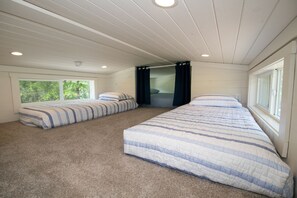 A bedroom with two beds, a window, and a ceiling fan. - The Jocassee Tiny House (Salem)