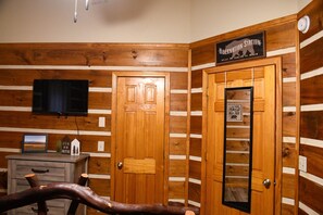 Cozy cabin-style room with a wooden door, cabinet, and chair, perfect for a relaxing retreat.