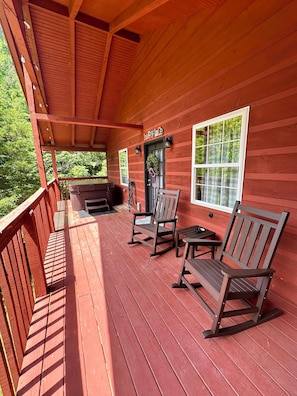 A wooden porch with rocking chairs, a bench, and a door labeled 'The Fireplace.'
