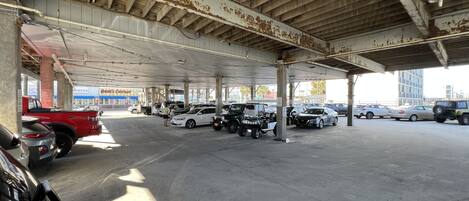 A parking garage with multiple levels and a variety of vehicles, including cars and a red truck.