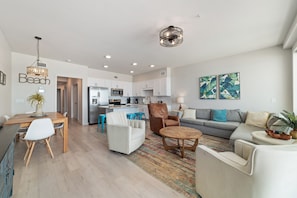 A modern living room with a sofa, coffee table, and dining area.