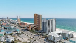 Een kuststadsgezicht met een opvallend hotel met een modern design, nabij een strand.