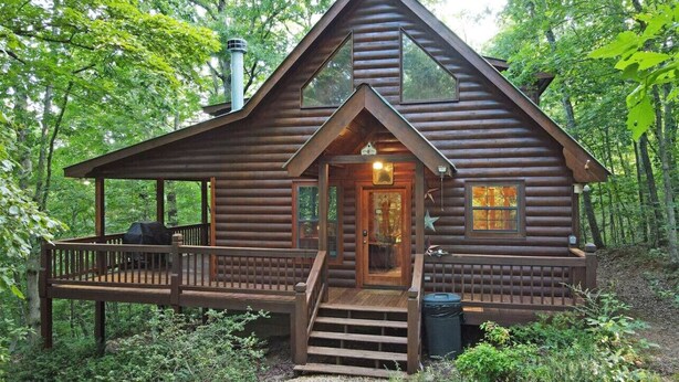 A log cabin with a porch, a chimney, and a small deck. - Wolf`s Den - Dogs OK- Hot Tub-Firepit-Wi-Fi-Fireplace-Covered Deck with Gas Grill (Blue Ridge)