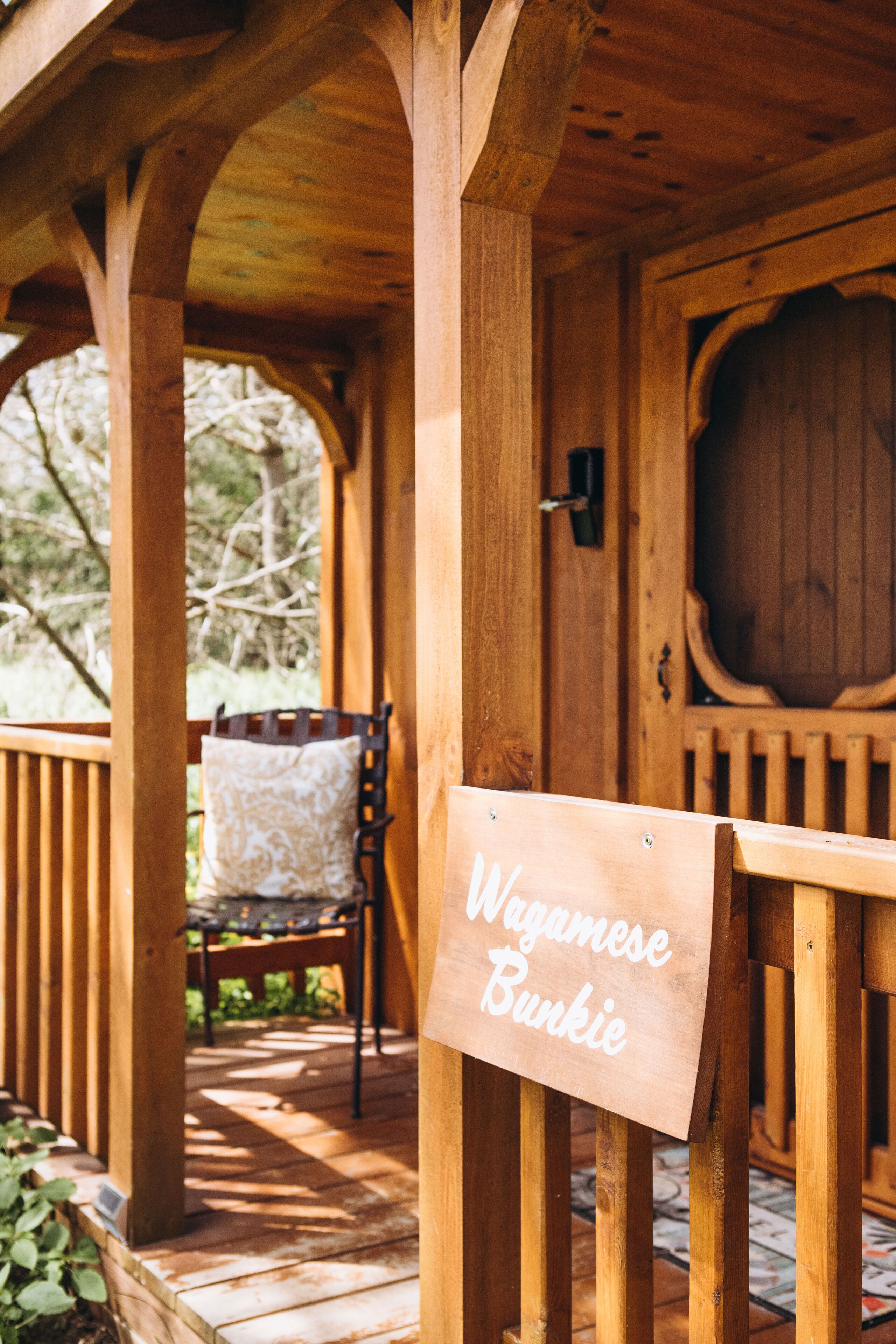 Een houten veranda met een bord waarop staat: Wagamese Bunkie.
