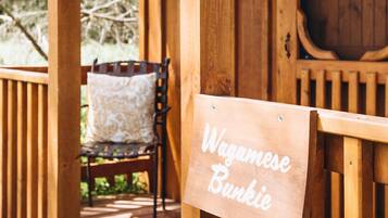 Een houten veranda met een bord waarop staat: Wagamese Bunkie.