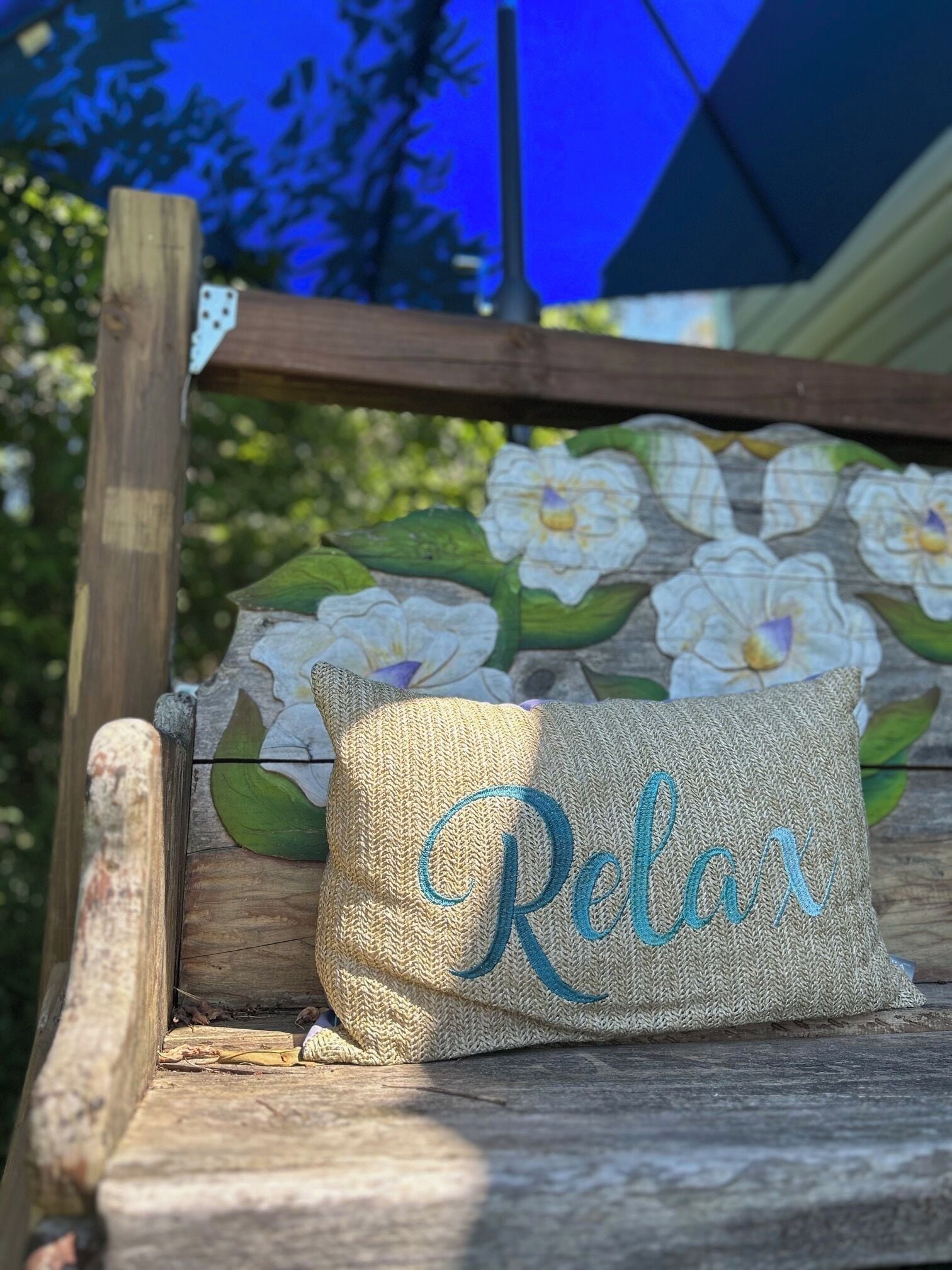 A bench with a cushion labeled 'Relax' and a floral mural in the background.