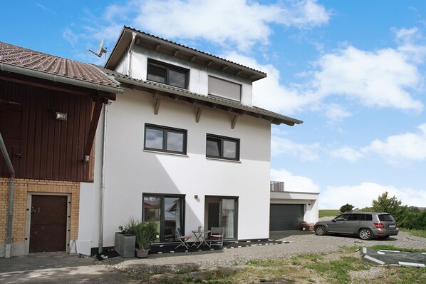 Ein zweistöckiges Haus mit Garage, Auffahrt und einem abgestellten SUV.