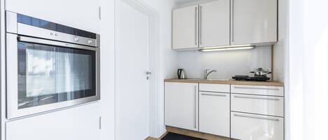 Een koelkast, een oven, een kookplaat, een koffiezetapparaat/waterkoker
