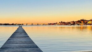 A wooden pier extending into calm water with a clear sky above. - Waterfront King Bed Courtyard Apartment (Sylvania)