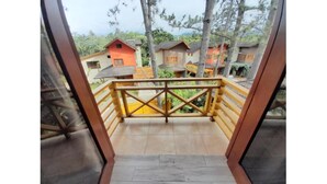 A wooden balcony with a view of multiple houses.