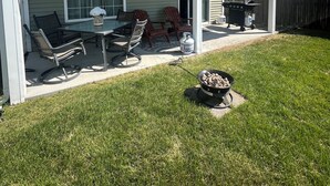Un patio couvert avec des meubles d’extérieur, un barbecue et un gril.
