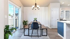 Uma área de refeições com mesa, cadeiras e um candelabro.
