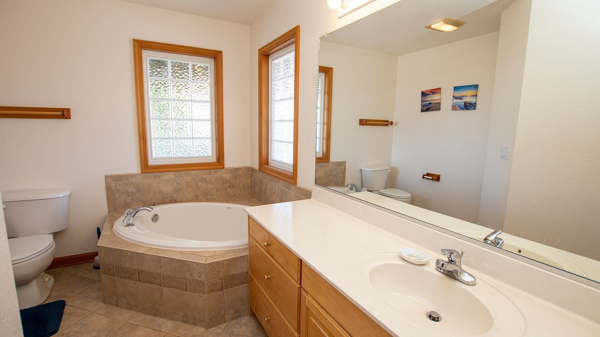 A bathroom with a bathtub, a toilet, a sink, and a large mirror.