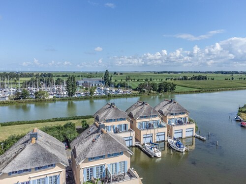 Maison au toit de chaume avec vue sur l'eau