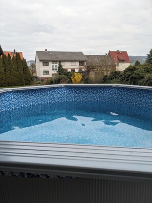 A swimming pool with a view of houses and trees in the background.