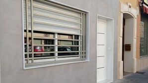 Une façade d’immeuble avec une grande fenêtre et une porte.