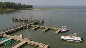 Un muelle con barcos y una pequeña embarcación en el agua.