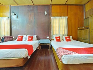 A hotel room with two beds, wooden flooring, and a wardrobe. - OYO 90595 Pelangi Beach Resort Cherating (Cherating)