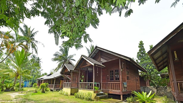 A wooden house with a porch and a small garden area. - OYO 90595 Pelangi Beach Resort Cherating (Cherating)