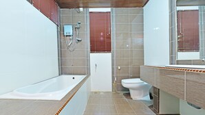 A modern bathroom with a bathtub, toilet, and shower area. - OYO 90595 Pelangi Beach Resort Cherating (Cherating)