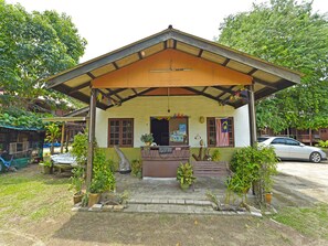 A small building with a porch, potted plants, and a car parked outside. - OYO 90595 Pelangi Beach Resort Cherating (Cherating)