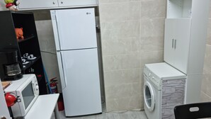 A compact kitchen with a refrigerator, microwave, and washing machine. - Stadion apt 2 Near Athens city center (Athina)